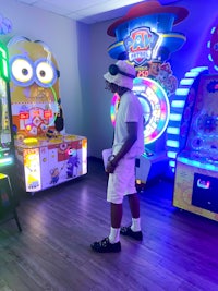 a man standing in front of a room full of arcade games